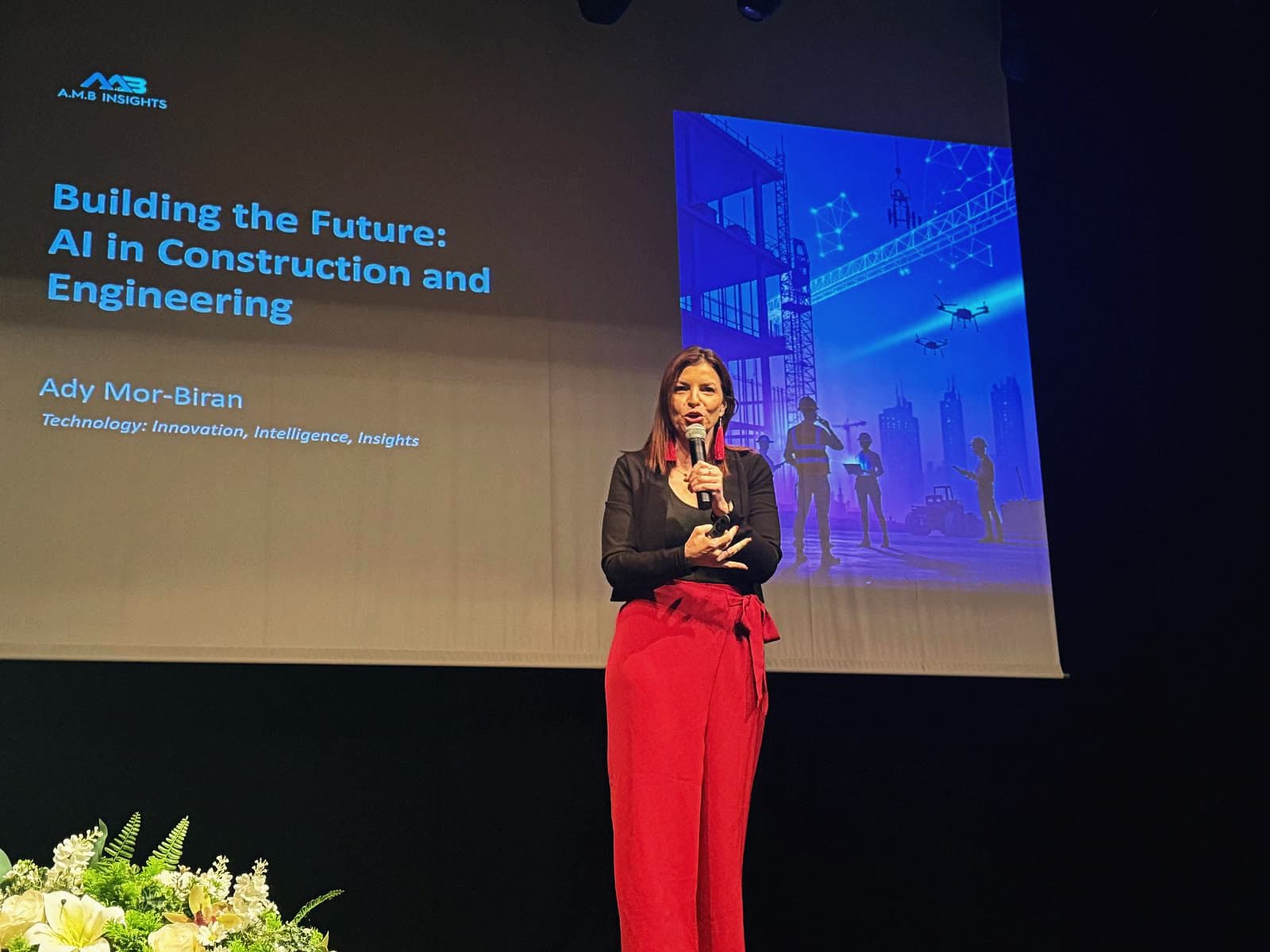 Ady Mor-Biran on a theatre stage in front of her AMB Insights slide, "Building the Future: AI in Construction and Engineering".